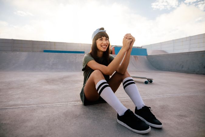 Cool woman relaxing outdoors at skate park