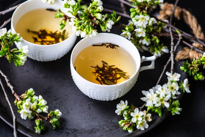 Tea time concept of green tea in cups with floral decor