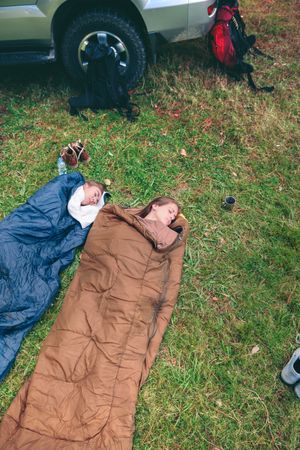Women resting inside of sleeping bags with 4x4 on background