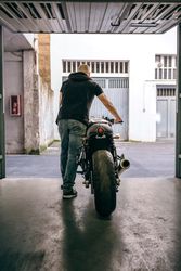Man with custom motorbike leaving the garage