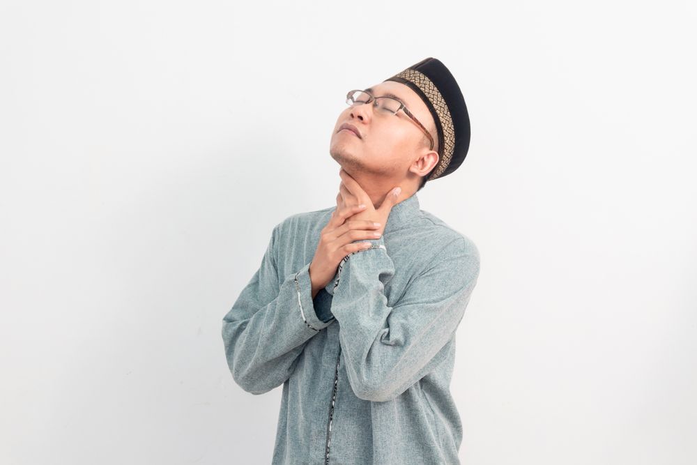 Asian Muslim man touching neck, thirsty gesture during fasting in Ramadan