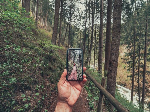 Tourist taking photo while walking on footpath