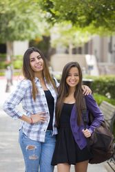 Female Students Carrying Backpacks on School Campus
