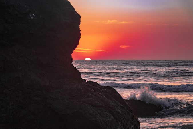 Colorful dusk seen from behind cliffs of rocky beach