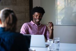Man sitting with laptop with colleague