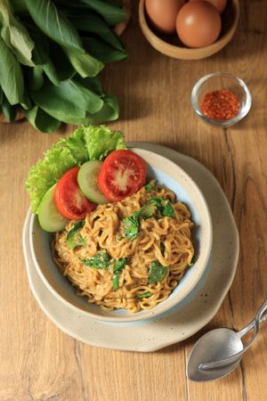 Top View Indomie Bangladesh, Mie Goreng with Spicy Sauce, vegetable, and Secret Chilli