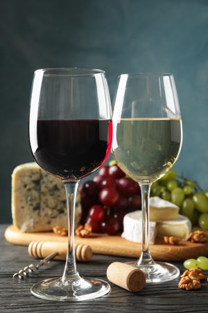 Grape, cheese, corkscrew, glasses with wine, on wooden background, copy space