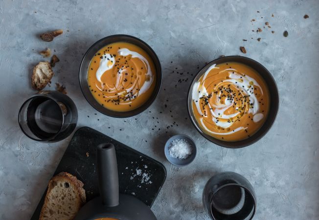 Bowls with pumpkin cream soup on table