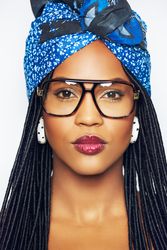 Studio portrait of woman with a serious expression wearing a blue wrap on her head