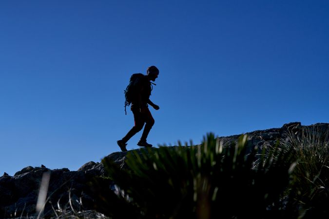 Silhouette of traveling man on rocky hill