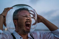 Distressed man with fish tank on head screaming