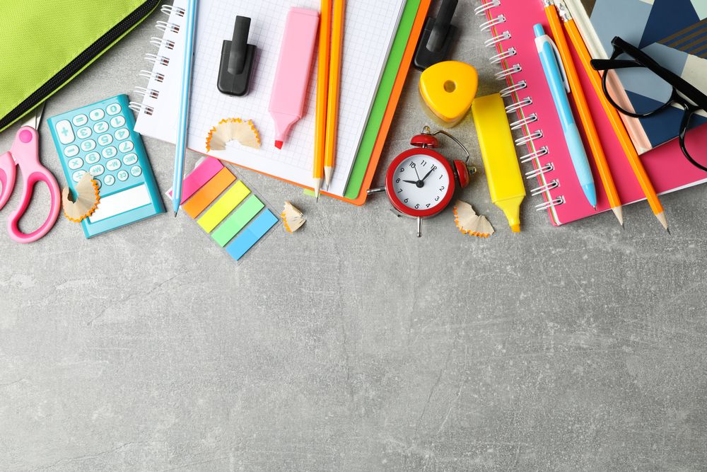 Grey desk with colorful stationary along the top with space for text