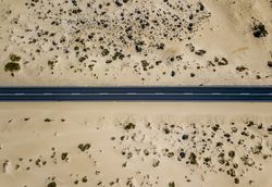 Straight road in sandy desert land
