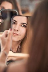 Woman looking at mirror in beauty salon