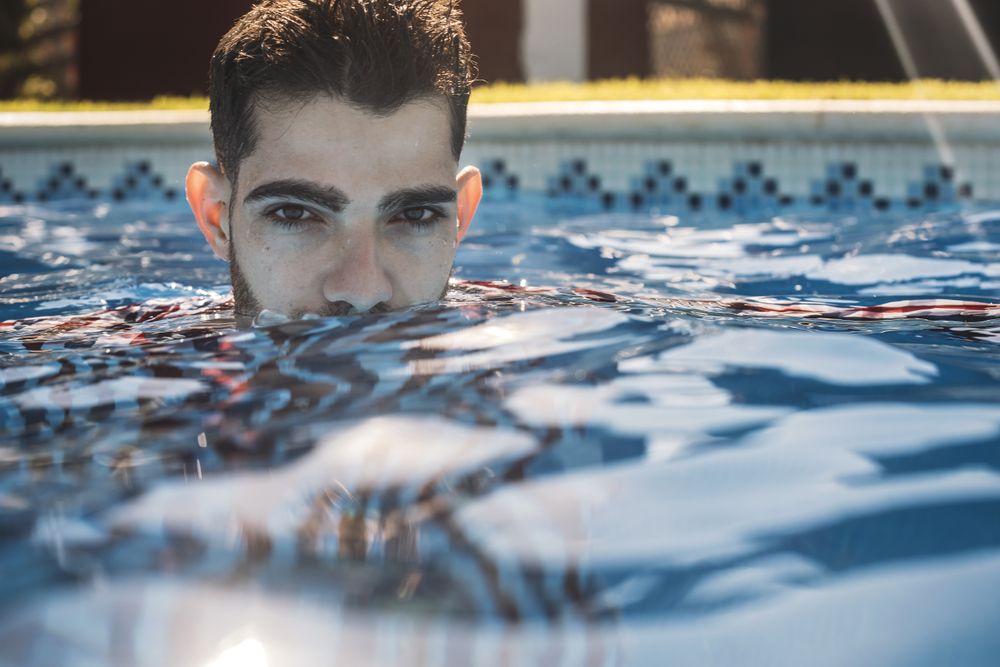 Dressed man in swimming pool