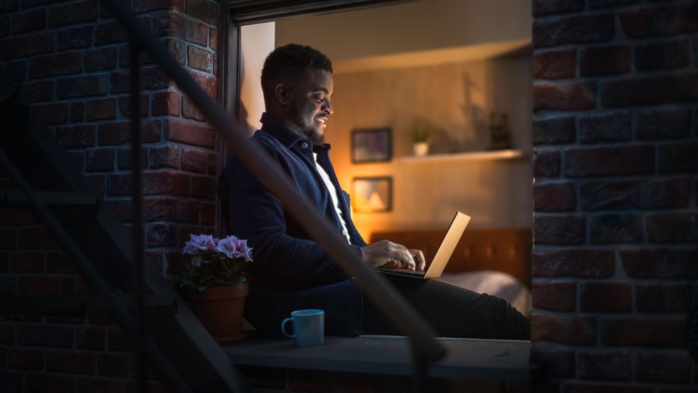 Portrait of a Young Male Freelancer Working on a Computer and Enjoying his Time, Making Progress on Project