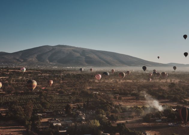 Hot air balloons flying descending back down in Teotihuacan Valley