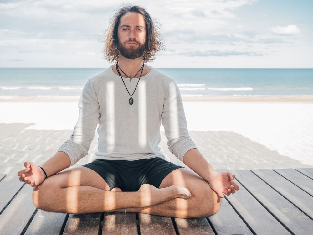 Man meditating on beach