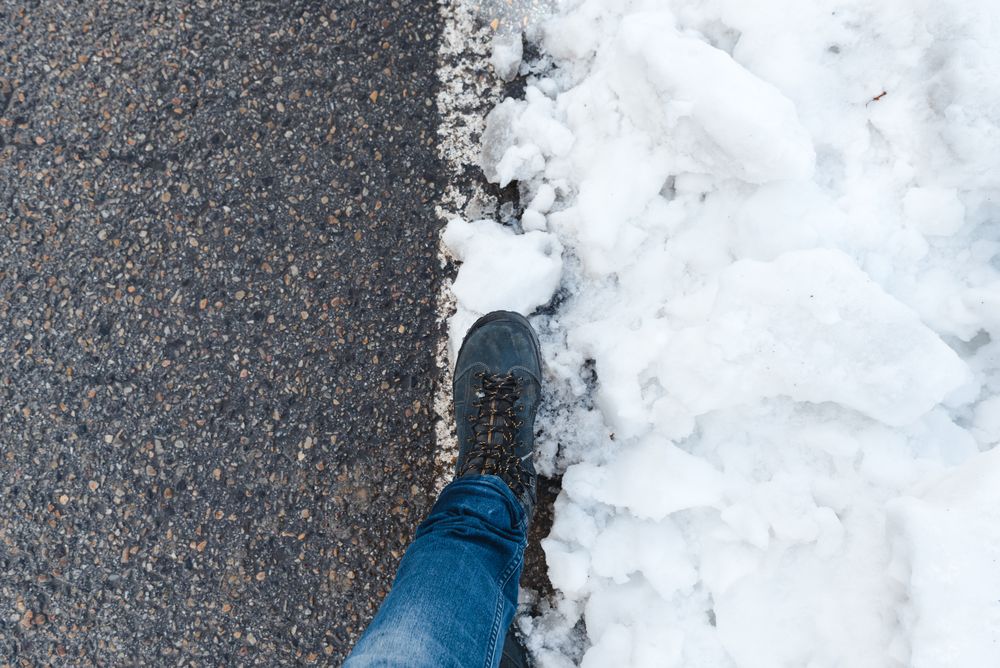 Faceless person standing on snowy road