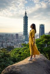 Young resting woman delighting in views in rock at big city