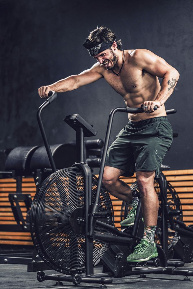 Hardworking male working out on gym bike