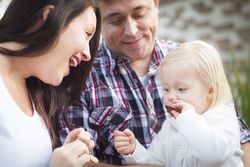 Adorable Little Girl Eating a Cookie with Mommy and Daddy