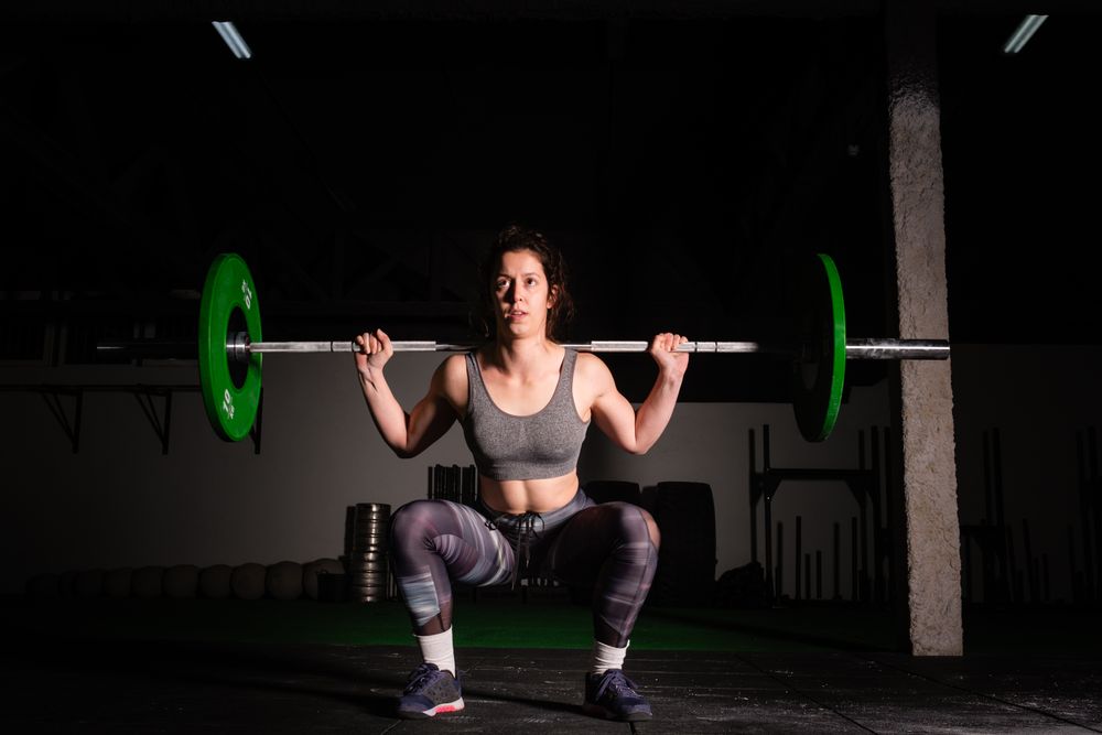 Woman lifting barbell in gym