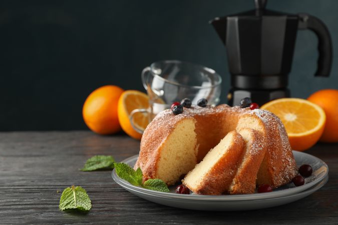 Cake with powdered sugar, berries and mint on wooden background, copy space