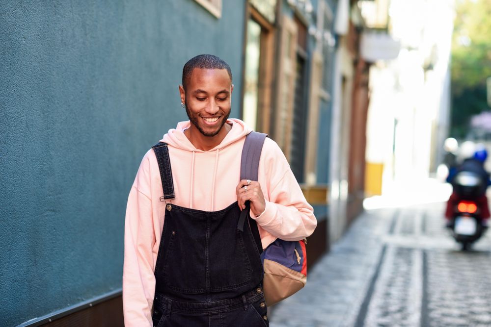 Happy male looking down while smiling on outdoor street