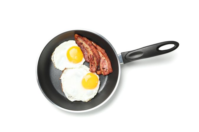 Eggs and bacon in frying pan, top view