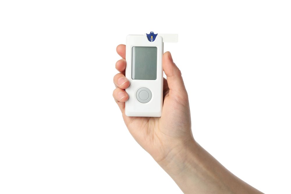 Female hand holds blood glucose meter, isolated on white background