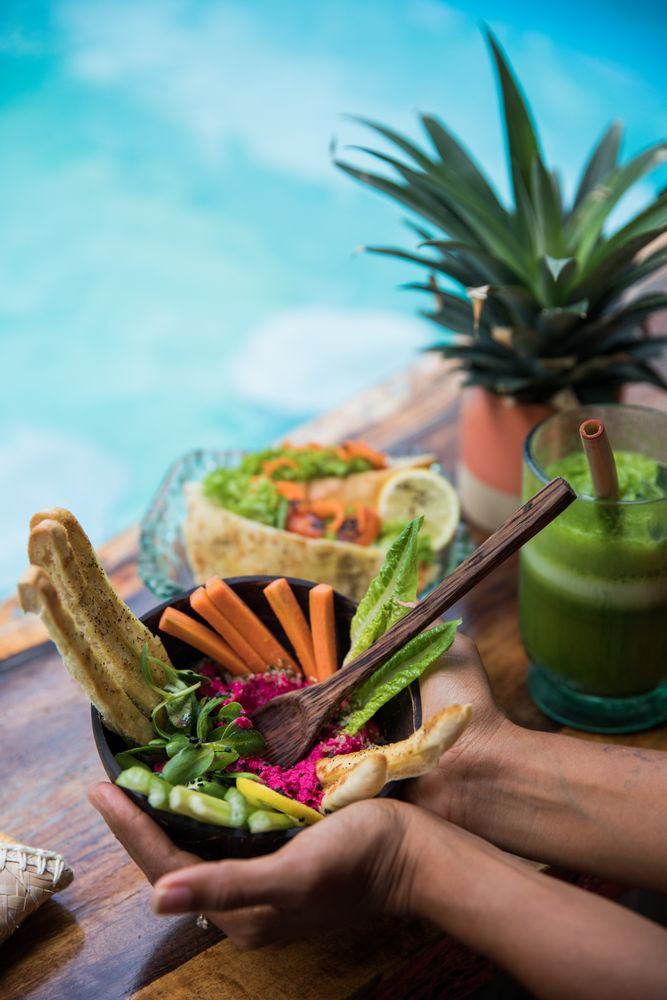 Black woman with fresh salad and shake on table