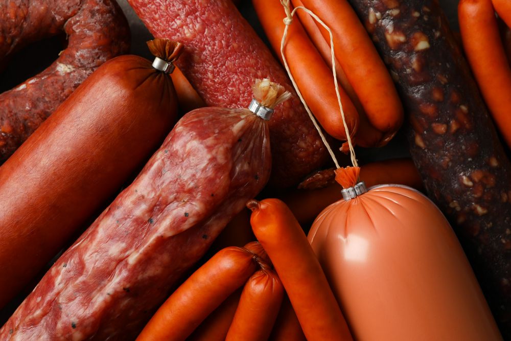Close up of variety of cured meats on kitchen board
