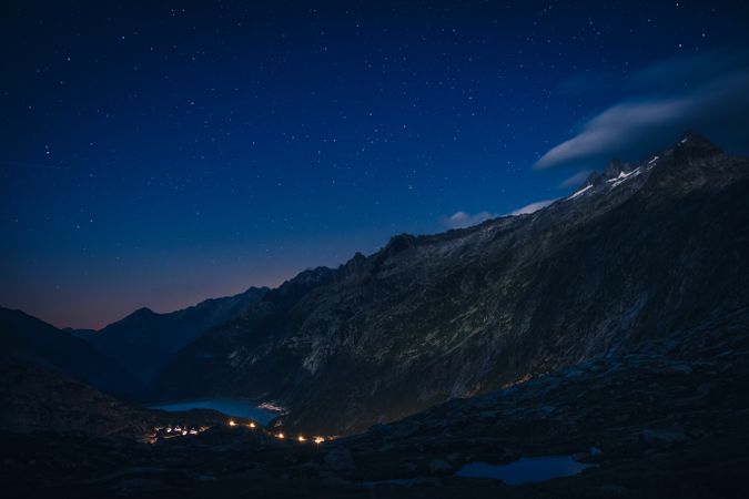 Lights above river in silent mountains at dusk