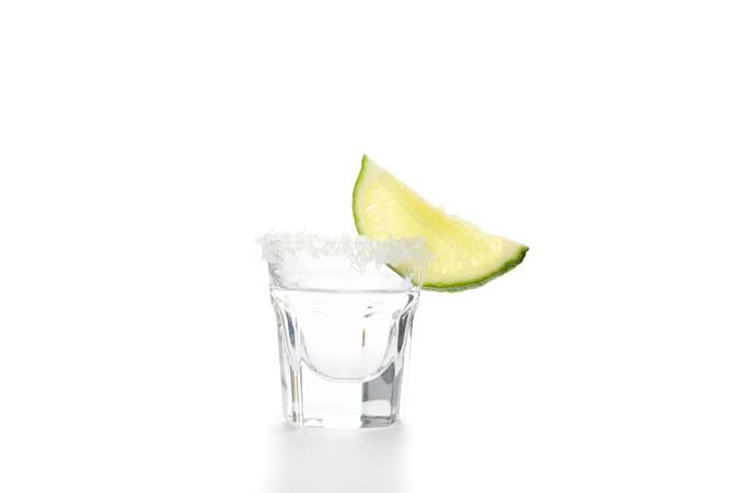 Tequila shot with slice of lime and salt isolated on blank background