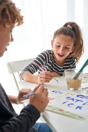 Positive children painting at table