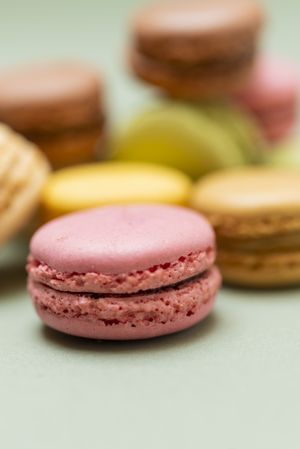 Close up of colorful macaroons scattered on a green table