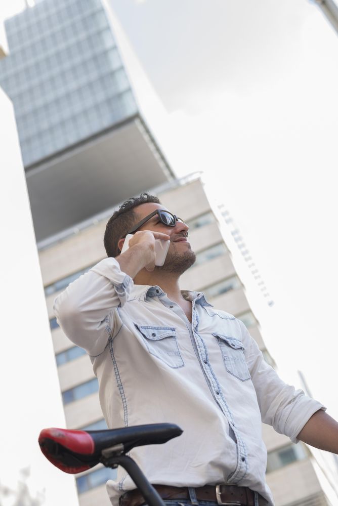 Male on phone standing in front of building