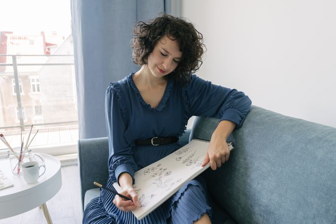 Woman artist drawing at sofa