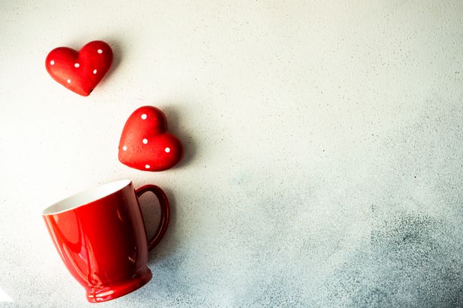 Red mug and dotted heart decorations for St. Valentine's day card with space for text