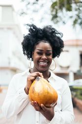 Latin American woman having fun in the city drinking coconuts