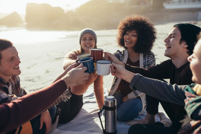 Group of friends spending time together at the beach having coffee