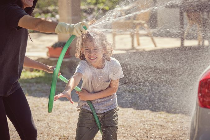 Woman washing car with son