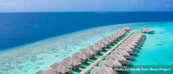 Two rows of overwater bungalows at a beach resort 5oNRz0