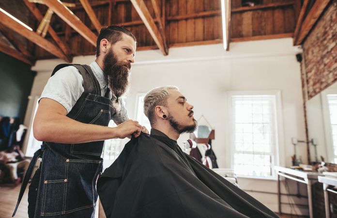 Barber adjusting customers cape