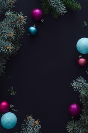 Branches and festive baubles bordering dark background