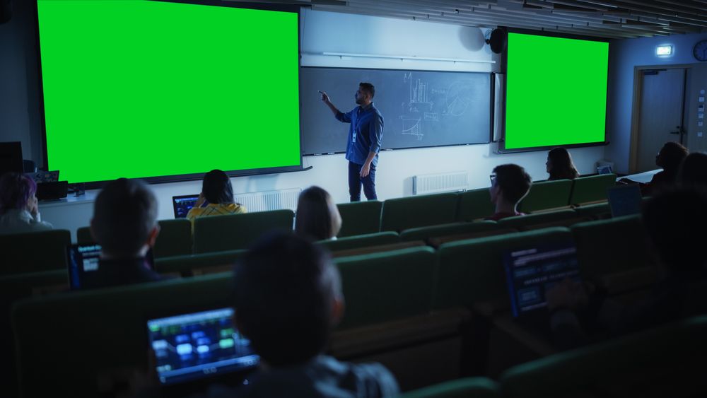 Young University Professor Explaining a Lecture, Pointing on a Green Screen Mock Up Display.