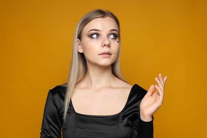 Portrait of a woman in a Halloween outfit on a yellow background