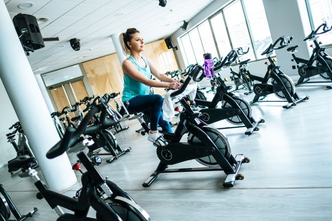 Woman with towel and water on exercise machine