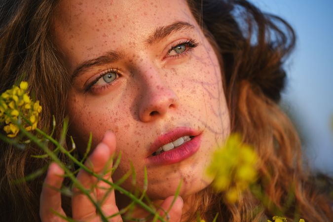 Crop woman with delicate yellow flowers in nature